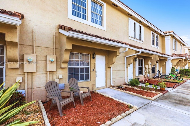 view of front of home featuring a tiled roof and stucco siding