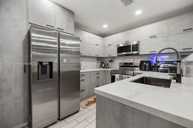 kitchen with light stone countertops, stainless steel appliances, tasteful backsplash, and sink