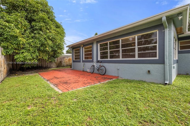 rear view of property with a patio area and a yard