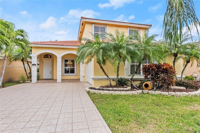 mediterranean / spanish-style home with a front yard