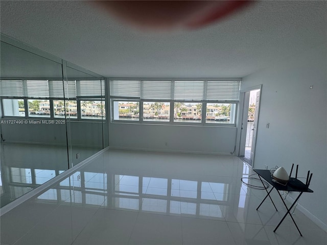 empty room featuring a textured ceiling and tile patterned floors