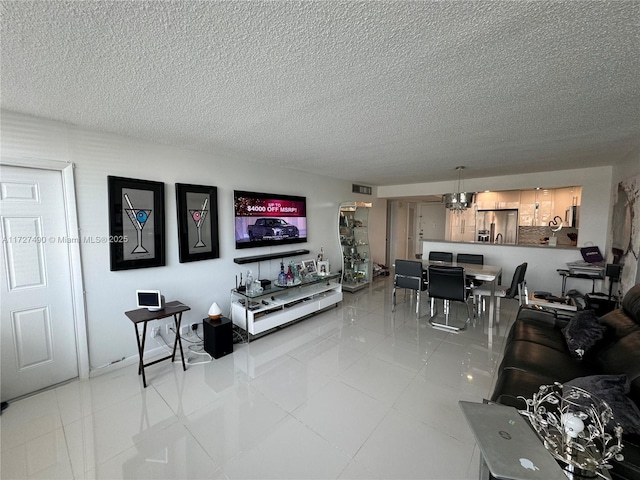 tiled living room with a textured ceiling and a notable chandelier