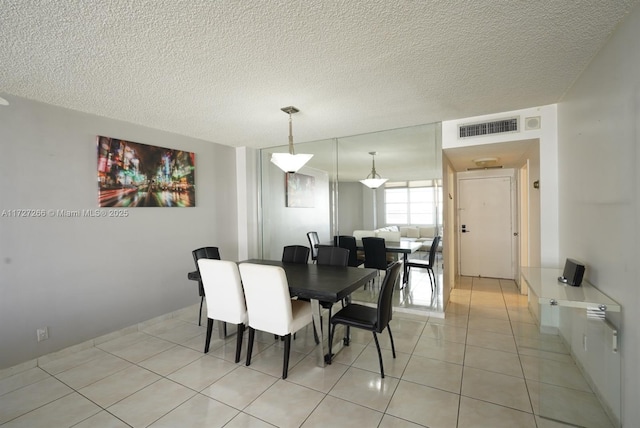 tiled dining area with a textured ceiling