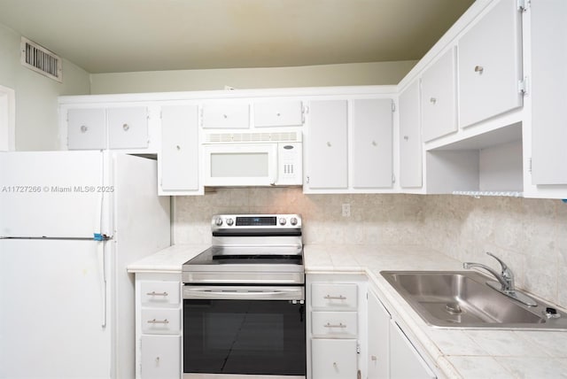 kitchen featuring tile countertops, sink, white cabinets, and white appliances