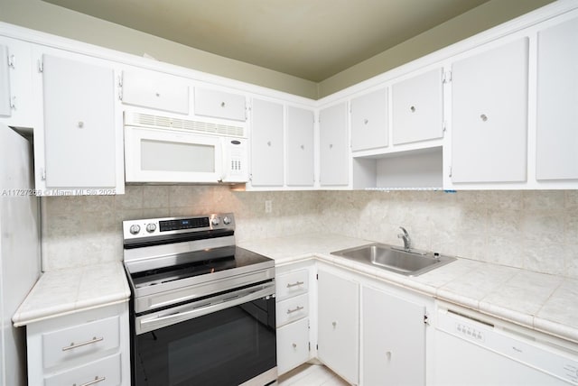 kitchen with tile countertops, decorative backsplash, sink, white appliances, and white cabinetry