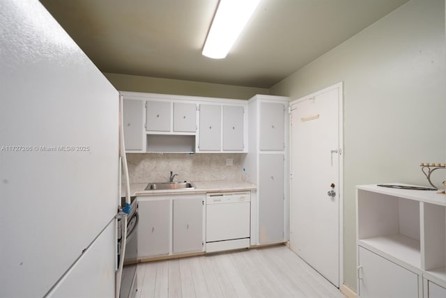 kitchen featuring white cabinetry, sink, white appliances, and backsplash