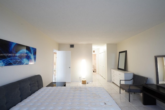 tiled bedroom featuring a textured ceiling and a closet