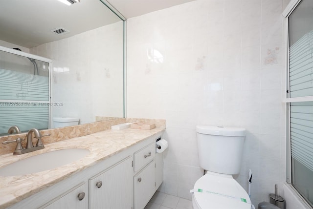 full bathroom featuring enclosed tub / shower combo, tile patterned flooring, vanity, tile walls, and toilet