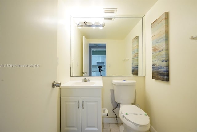 bathroom with toilet, vanity, and tile patterned floors