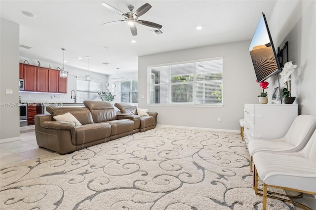 tiled living room with ceiling fan and sink