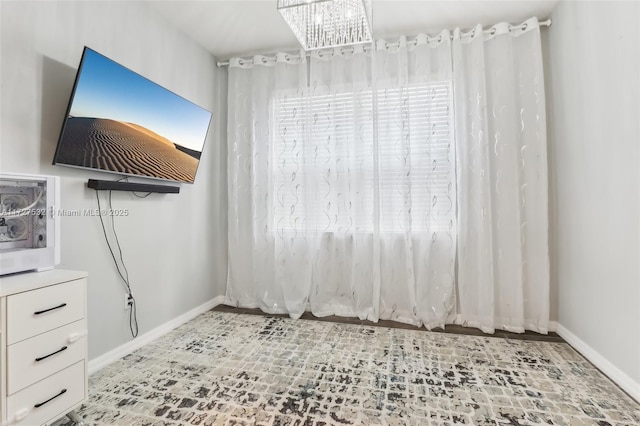 unfurnished room featuring a notable chandelier