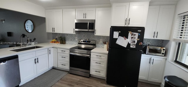 kitchen with decorative backsplash, sink, dark wood-type flooring, appliances with stainless steel finishes, and white cabinets