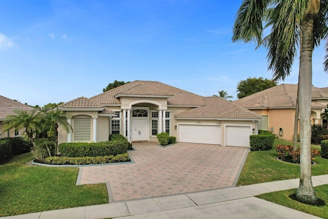 mediterranean / spanish house with a front yard and a garage