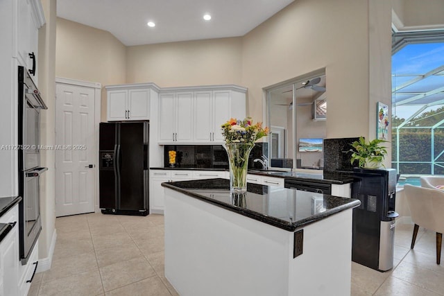 kitchen with backsplash, white cabinetry, black appliances, and dark stone counters