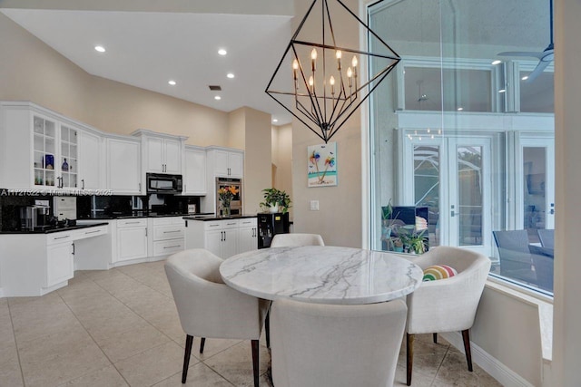 tiled dining room with an inviting chandelier