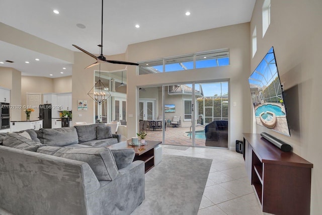 living room featuring light tile patterned floors, a towering ceiling, and a notable chandelier