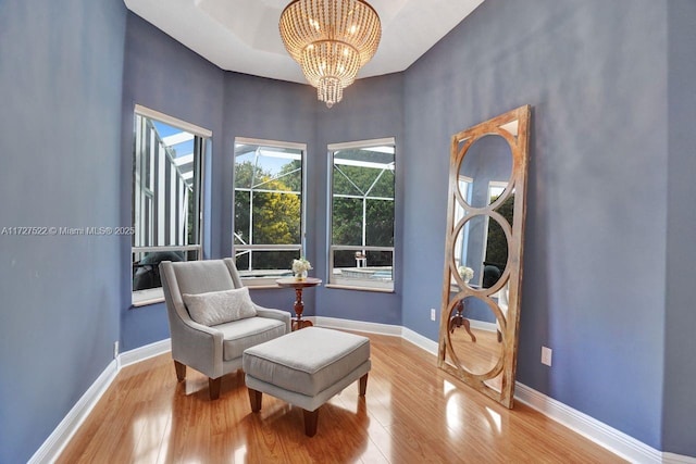 living area featuring an inviting chandelier and light hardwood / wood-style floors