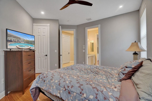 bedroom featuring ceiling fan, light hardwood / wood-style floors, ensuite bathroom, and a closet