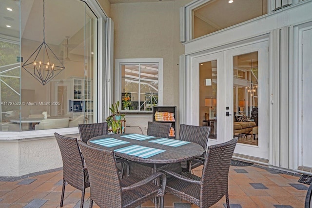 sunroom with french doors and a notable chandelier