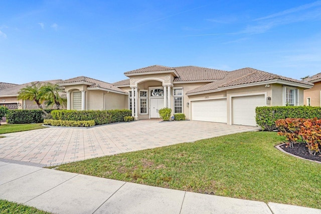 mediterranean / spanish home with a front lawn and a garage