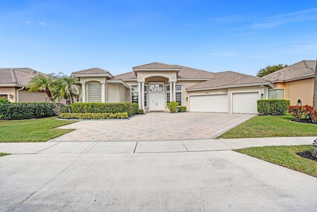 mediterranean / spanish-style house featuring a front lawn and a garage