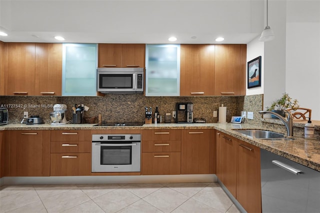 kitchen featuring decorative light fixtures, sink, light tile patterned flooring, light stone countertops, and stainless steel appliances