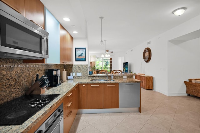 kitchen featuring stainless steel appliances, decorative backsplash, sink, kitchen peninsula, and ceiling fan