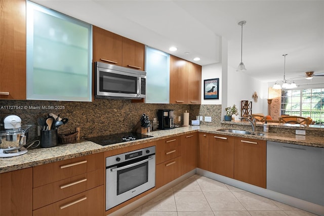 kitchen featuring decorative light fixtures, sink, backsplash, and stainless steel appliances