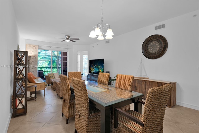 dining area featuring light tile patterned flooring and ceiling fan with notable chandelier