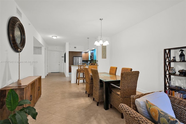 tiled dining space featuring a chandelier