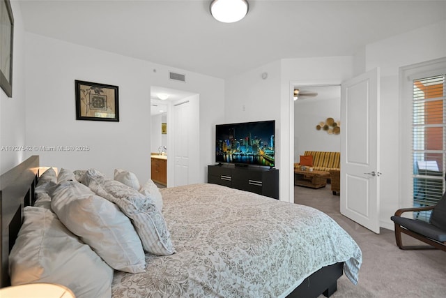 bedroom with carpet flooring, sink, and ensuite bath