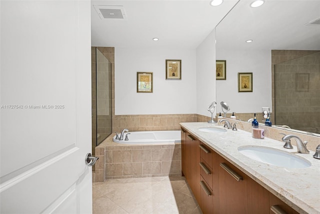 bathroom featuring plus walk in shower, vanity, and tile patterned flooring