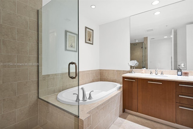 bathroom featuring plus walk in shower, tile patterned floors, and vanity