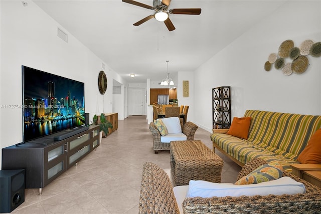 tiled living room featuring ceiling fan with notable chandelier