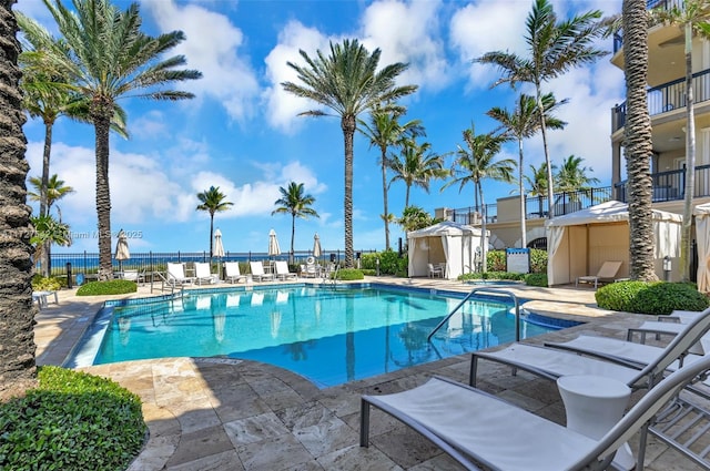 view of pool featuring a water view and a patio area