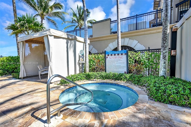 view of swimming pool with a hot tub