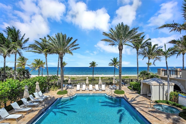 view of pool with a water view and a patio