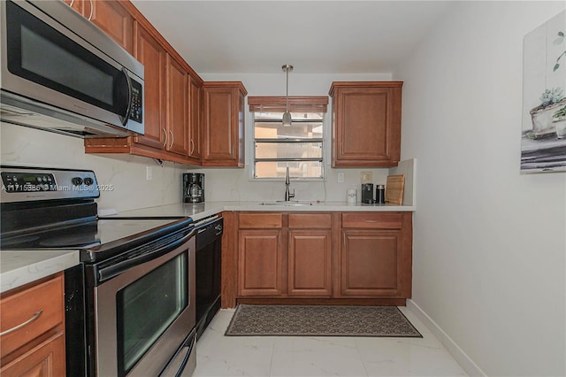 kitchen with decorative light fixtures, sink, and stainless steel appliances