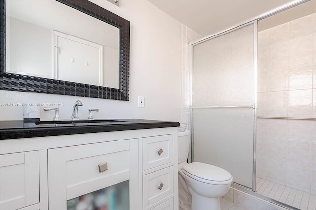 bathroom with vanity, toilet, and a shower with door