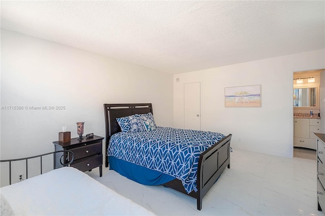 bedroom with a textured ceiling and connected bathroom