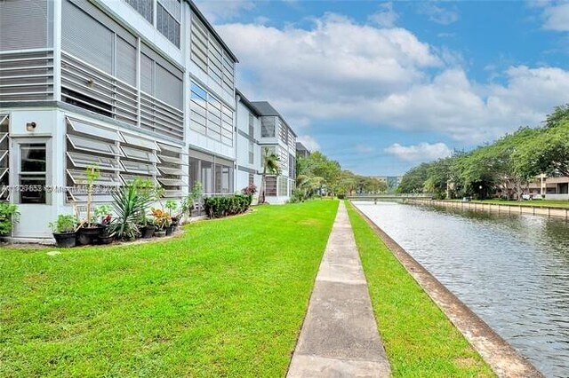 view of community with a water view and a lawn