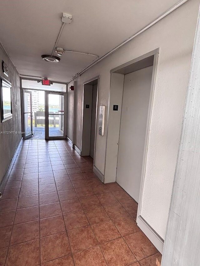 1401 NE Miami Gardens Dr Unit 892, Miami, FL 33179 - corridor with elevator and tile patterned flooring