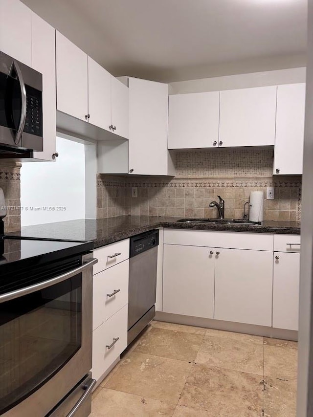 1401 NE Miami Gardens Dr Unit 892, Miami, FL 33179 - kitchen with appliances with stainless steel finishes, dark stone countertops, white cabinets, and sink