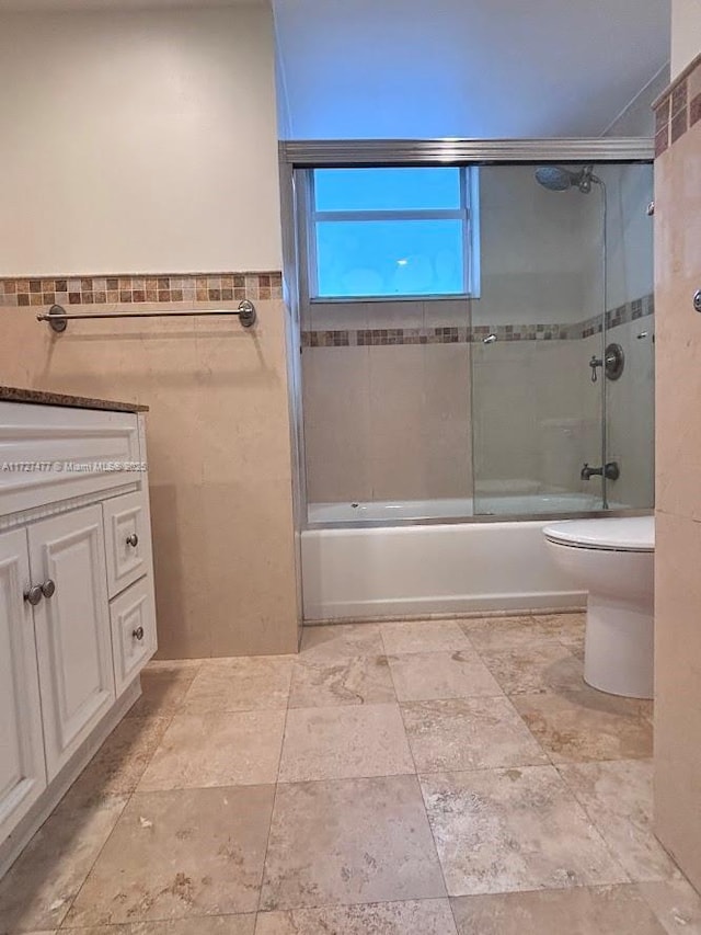 1401 NE Miami Gardens Dr Unit 892, Miami, FL 33179 - full bathroom featuring tile walls, combined bath / shower with glass door, vanity, and toilet