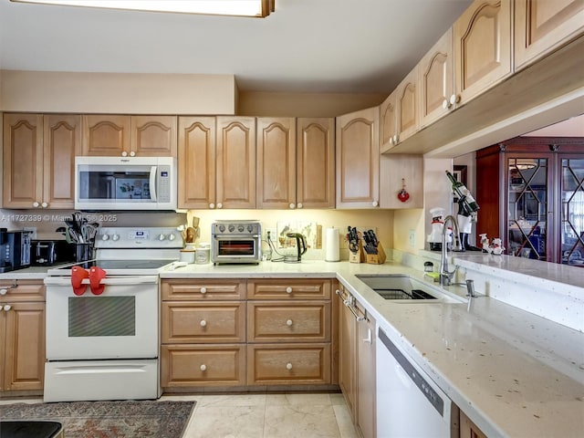 kitchen with sink, white appliances, and light brown cabinets