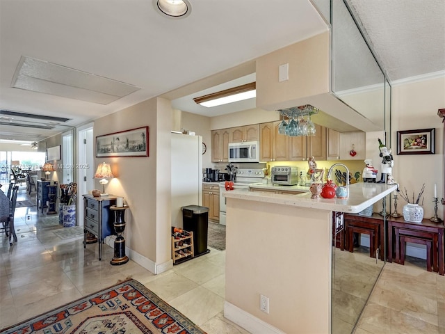 kitchen featuring a breakfast bar, kitchen peninsula, crown molding, white appliances, and light brown cabinets