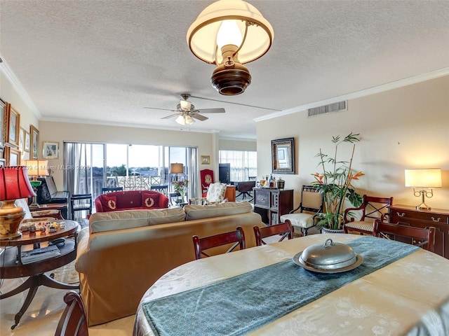 dining area with ceiling fan, a textured ceiling, and ornamental molding