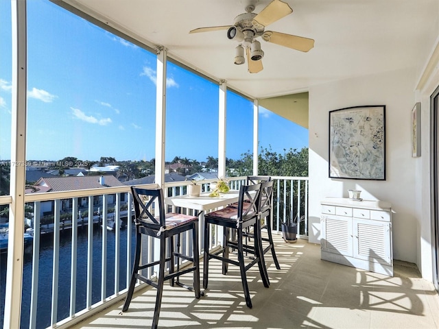 balcony featuring ceiling fan and a water view