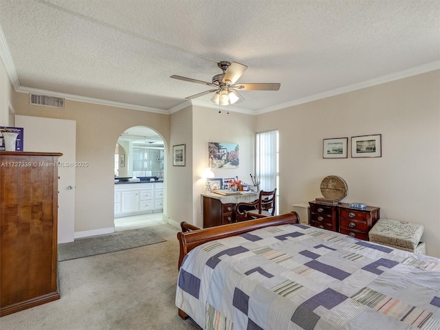 bedroom with ceiling fan, a textured ceiling, light carpet, and connected bathroom