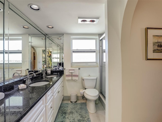 bathroom with toilet, vanity, an enclosed shower, and plenty of natural light